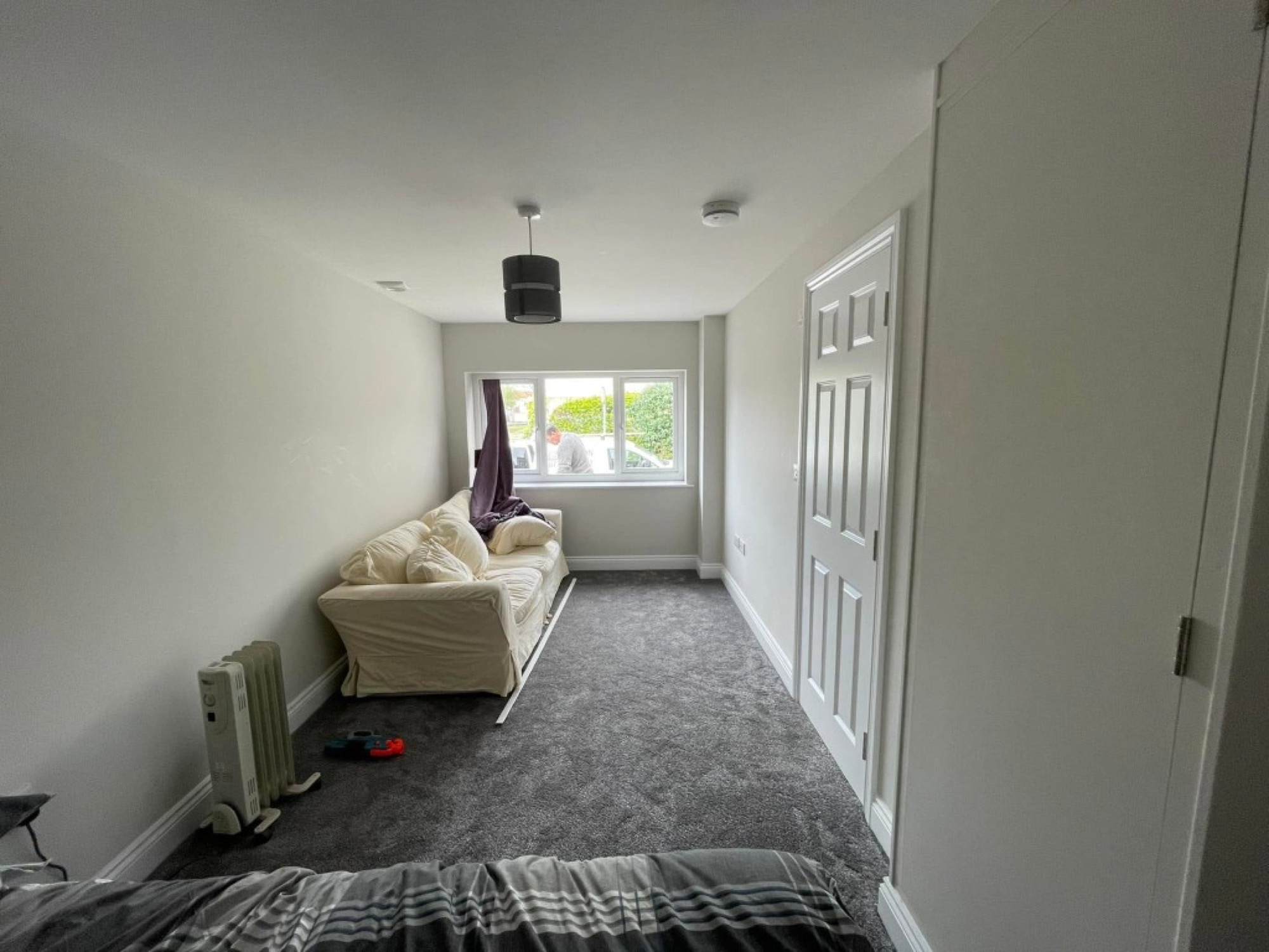 Garage conversion — completed living space with sofa and window